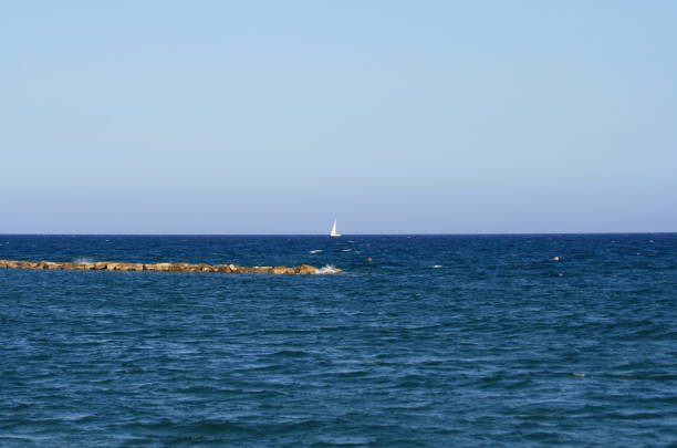 istock Blue sea with white sail on horizon 1155388846
