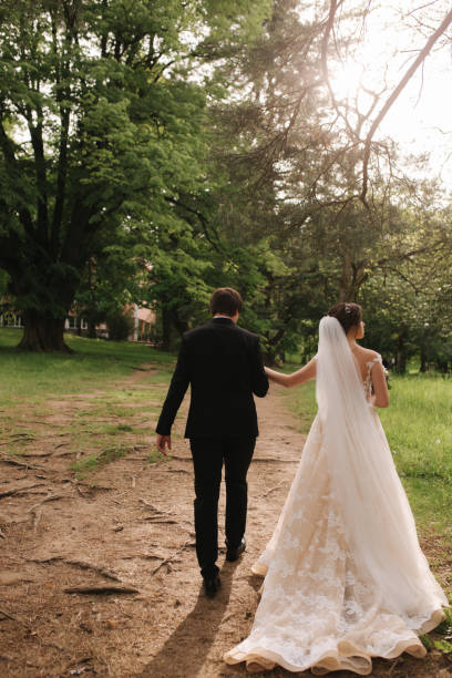 istock Back view of broom and bride walking in the forest 1155390839
