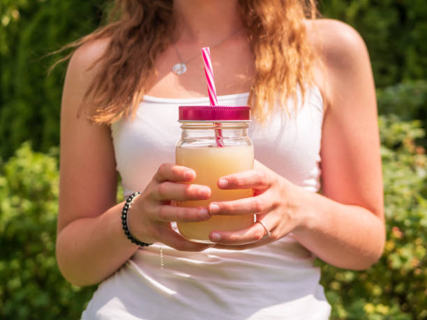 istock Young woman with a summer drink in her hands 1155391165