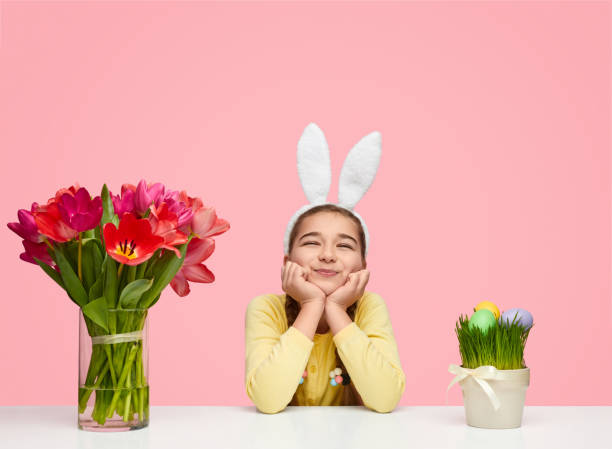 istock Adorable girl with tulips on table for Easter 1155391596