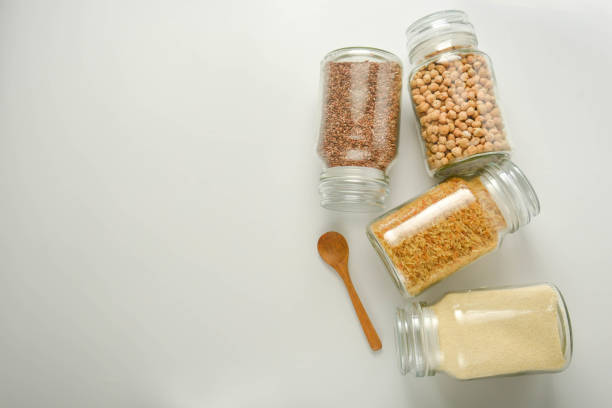 istock Various raw cereals in glass jar. Zero waste concept. Food storage. Flat lay. White background. 1155392196