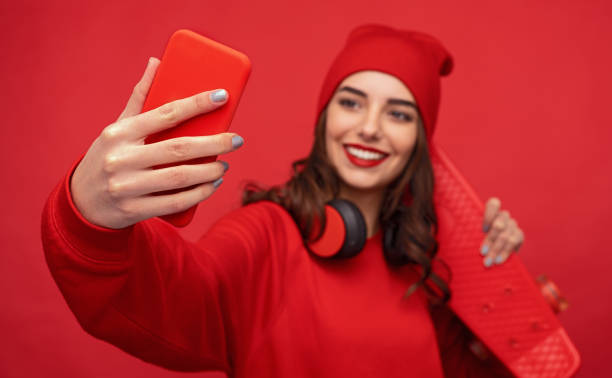 istock Hipster girl in red clothes taking selfie 1155392315