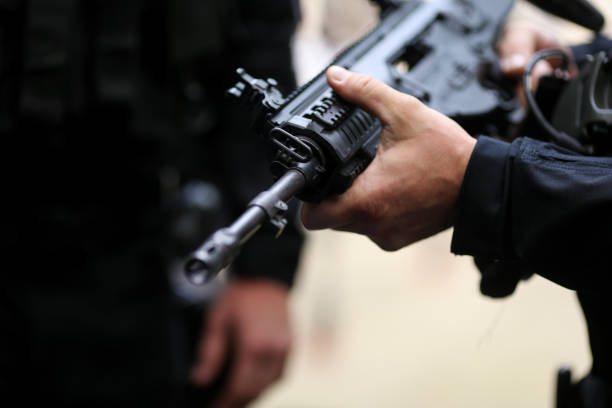 istock Details with the hands of a man holding an automatic rifle 1155392317