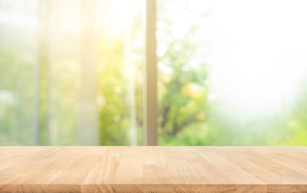 tablero de madera (barra de mostrador) en desenfoque de ventana con hermoso jardín en el fondo de la mañana - mesa de preparación en la cocina fotografías e imágenes de stock