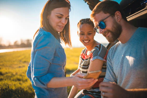 istock Friends standing next to a car and talking 1155392723
