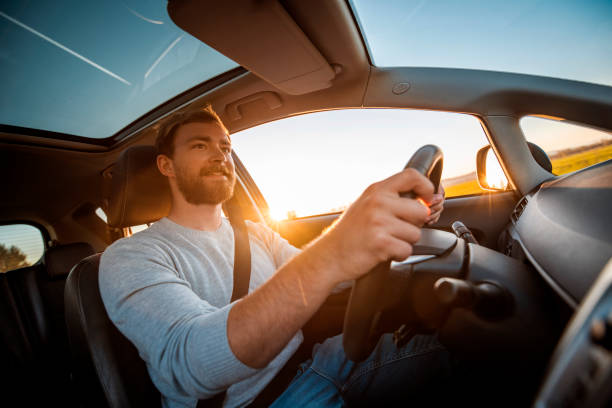 Young man driving car on a sunny day