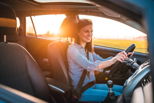 istock Young woman driving car on a sunny day 1155392775