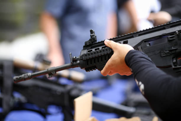 istock Details with the hands of a man holding an automatic rifle 1155393891