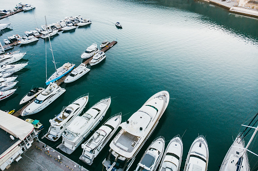 Aerial view of white yachts and boats moored in harbour pier, luxury vacation concept, toned