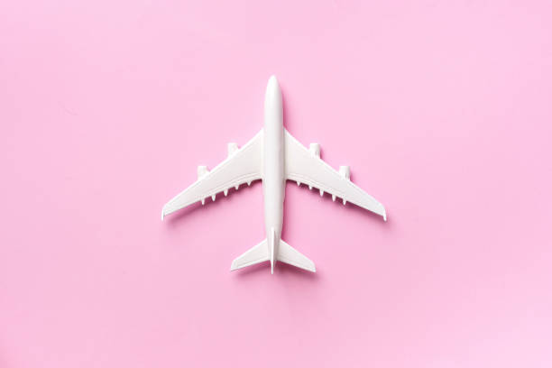 istock Creative layout. Top view of white model plane, airplane toy on pink pastel background. Flat lay with copy space. Trip or travel banner 1155398106