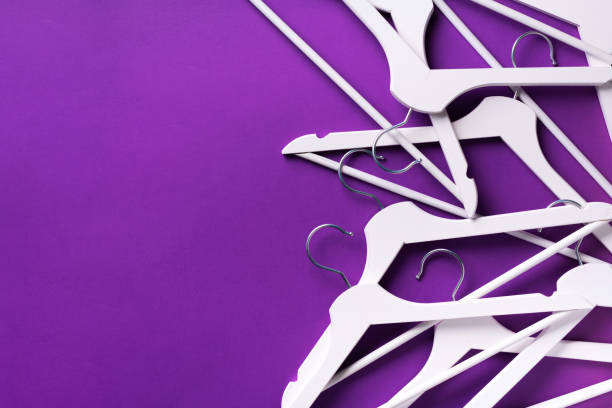 istock White clothes hangers on violet background with copy space. Flat lay. Top view. Minimalism style. Creative layout. Fashion, store sale, shopping concept. Banner for feminine blog 1155398143