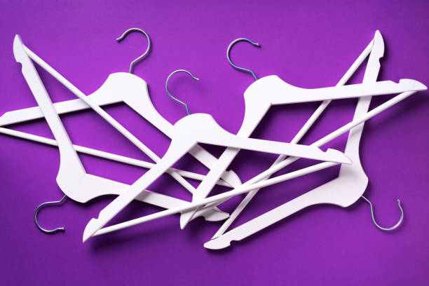 istock White clothes hangers on violet background with copy space. Flat lay. Top view. Minimalism style. Creative layout. Fashion, store sale, shopping concept. Banner for feminine blog 1155398211