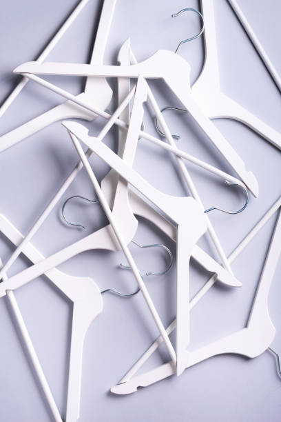 istock White clothes hangers on grey background with copy space. Flat lay. Top view. Minimalism style. Creative layout. Fashion, store sale, shopping concept. Banner for feminine blog 1155398230