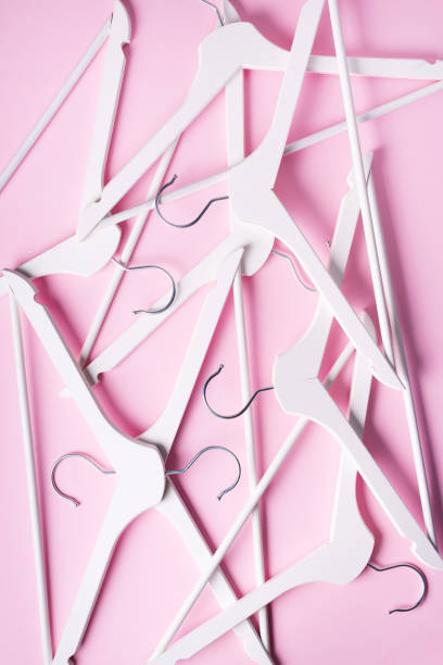 istock White clothes hangers on pink background with copy space. Flat lay. Top view. Minimalism style. Creative layout. Fashion, store sale, shopping concept. Banner for feminine blog 1155398364