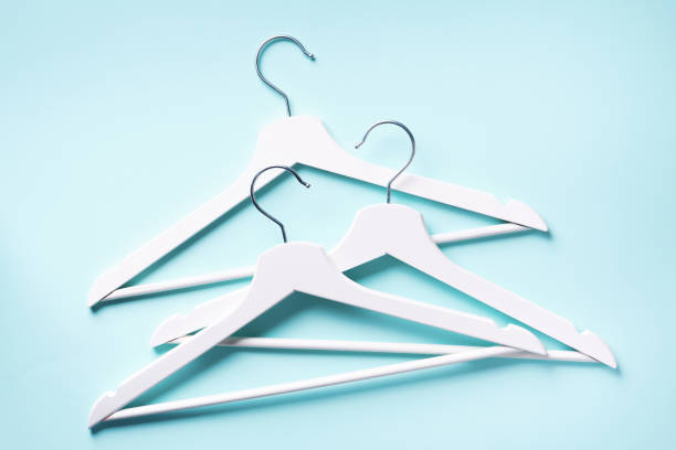 istock White clothes hangers on blue background with copy space. Flat lay. Top view. Minimalism style. Creative layout. Fashion, store sale, shopping concept. Banner for feminine blog 1155398372