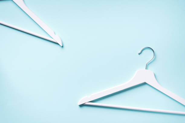 istock White clothes hangers on blue background with copy space. Flat lay. Top view. Minimalism style. Creative layout. Fashion, store sale, shopping concept. Banner for feminine blog 1155398386