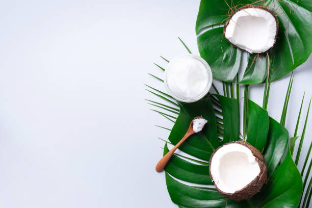 istock Green tropical monstera leaves, ripe coconuts, coconut oil on grey background with copy space. Top view. Summer creative layout. Skin care cosmetics. Hair, body treatment 1155398541