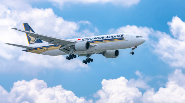 Airplane Boeing 777 of Singapore Airlines flying through clouds sky prepare to landing stock photo