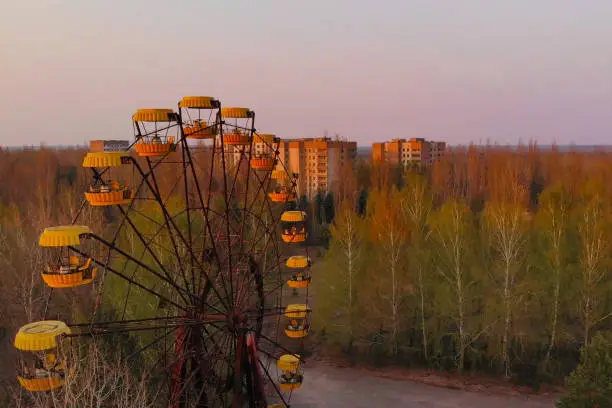 Rusty ferris wheel in the amusement park of the city of Pripyat. Ferris wheel in the City of Pripyat at sunset time. Apocalyptic city of Pripyat after a nuclear explosion at a nuclear power plant.