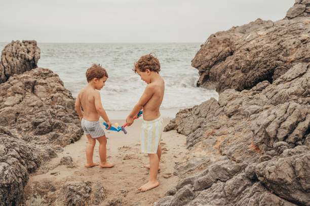 Boy playing in the rocks at the beach