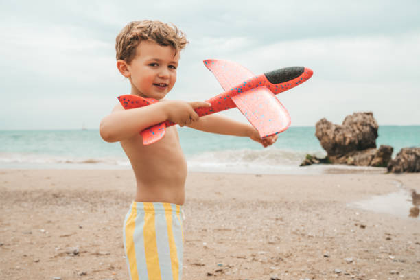 istock Boy playing with airplane toy at the beach 1155407206