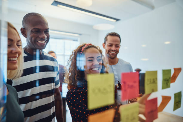 istock Smiling office colleagues brainstorming together with sticky notes 1155407652