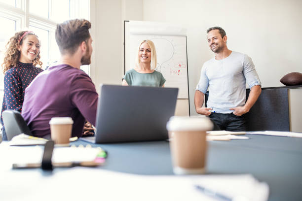istock Smiling group of designers talking together after a boardroom presentation 1155407753