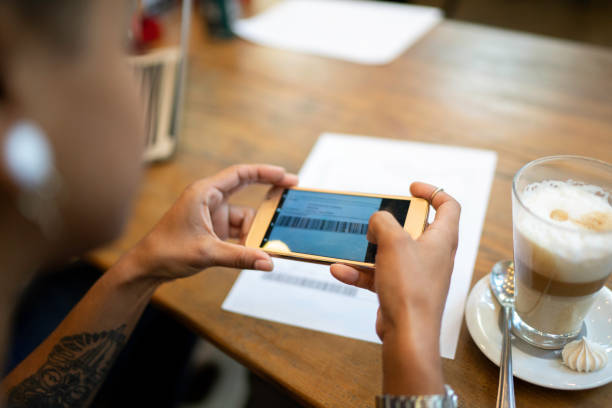 młoda kobieta płacąca rachunki przez telefon w kawiarni - restaurant wireless technology office worker business zdjęcia i obrazy z banku zdjęć