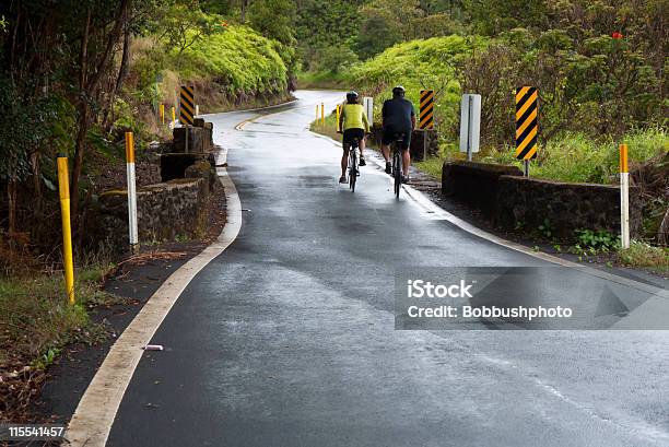 Dos Ciclistas En Lluvia Dampened Rural Road Foto de stock y más banco de imágenes de Andar en bicicleta - Andar en bicicleta, Clima tropical, Escena rural