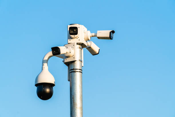 cctv cameras isolated on blue sky background - peeking analyzing staring watching imagens e fotografias de stock