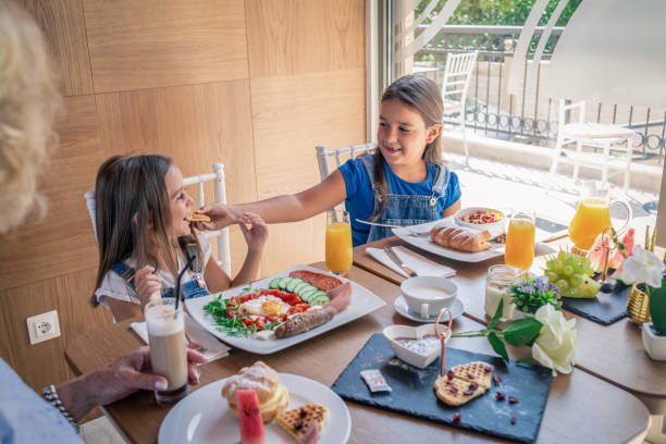 istock grandmother enjoying breakfast with her granddaughters 1155418693