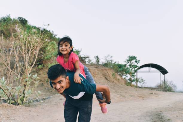 istock Brother takes his young sister piggyback while hiking 1155420510