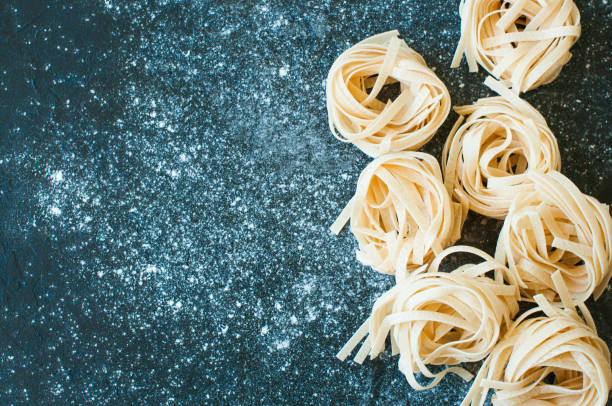 istock Homemade uncooked pasta on a black background 1155420830