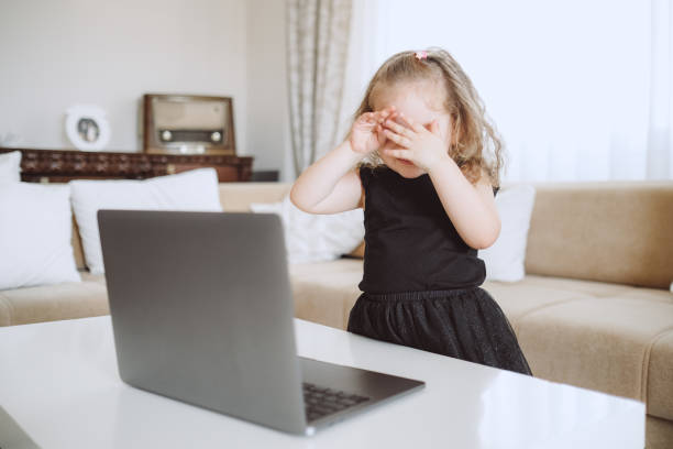istock Little student girl with laptop pc at home 1155420969