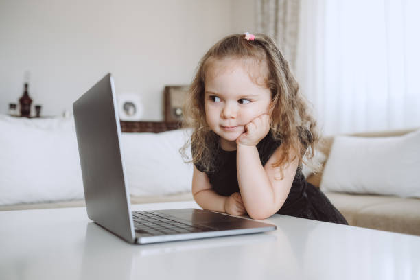 istock Little student girl with laptop pc at home 1155421146