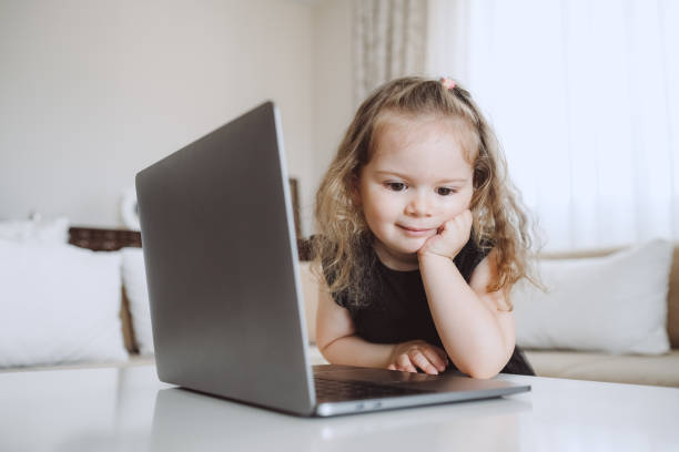 istock Little student girl with laptop pc at home 1155422236