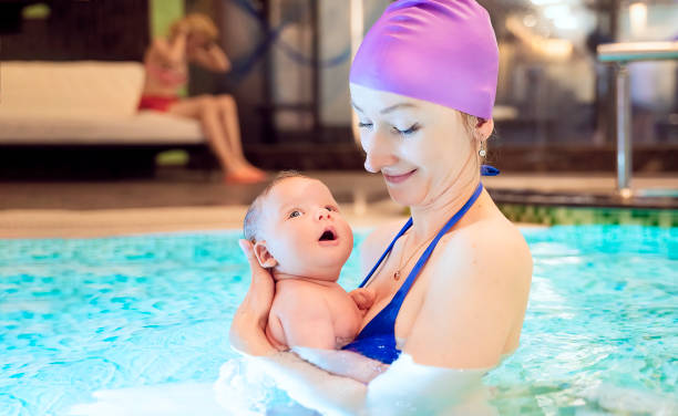 istock Mother swimming with baby in pool 1155426125