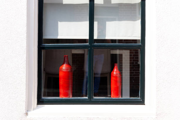 Gevel van een gebouw met een raam en rode vasen