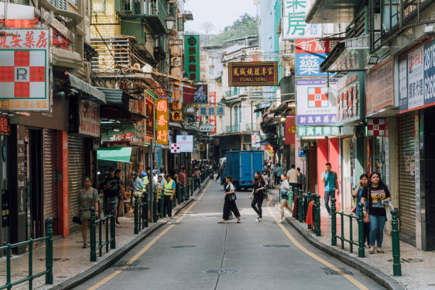 Macau, China - April 29, 2019: Daytime view of a street in Macau, with people walking and traffic of cars and trucks