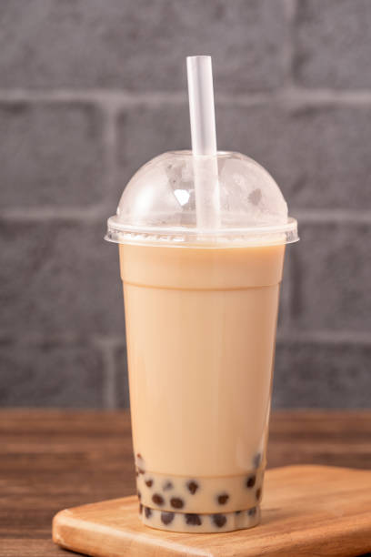 istock Takeout with disposable item concept popular Taiwan drink bubble milk tea with plastic cup and straw on wooden table background, close up, copy space 1155434480