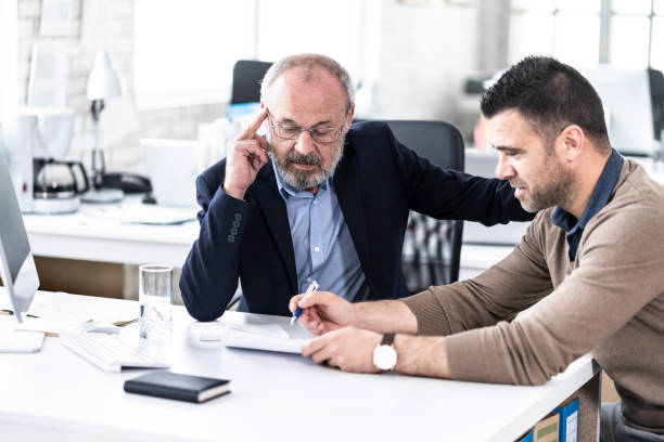 istock Mature businessman discussing project with male assistant 1155435019