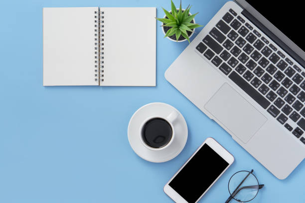 business concept. clean bright light blue office table desk, minimal style with laptop coffee and smart phone, copy space, top view, flat lay, mockup - above laptop desk computer imagens e fotografias de stock