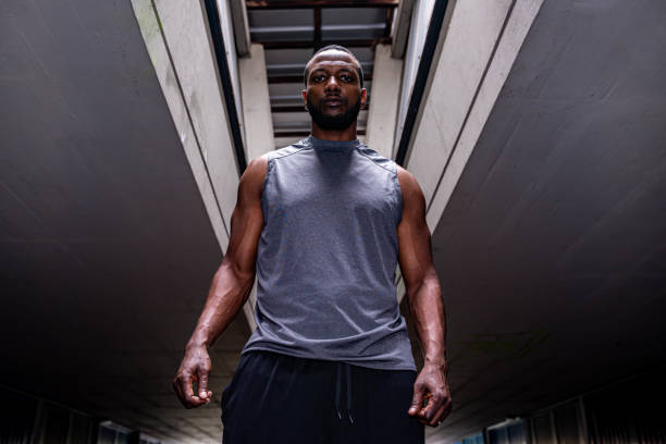 istock Young male athlete standing in a dark corridor 1155438951