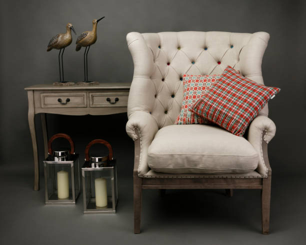 Armchair and 2 cushions with side table on grey background Armchair and 2 cushions with side table with ornaments on grey background couch arm rest stock pictures, royalty-free photos & images