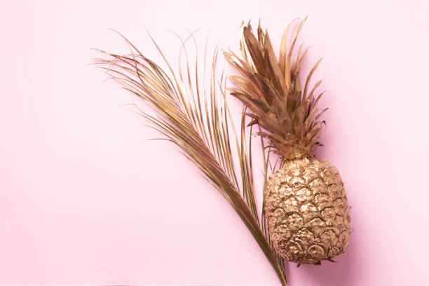 istock Creative layout. Gold pineapple and palm leaf on pink background with copy space. Top view. Tropical flat lay. Exotic food concept, crazy trend. Banner 1155442251