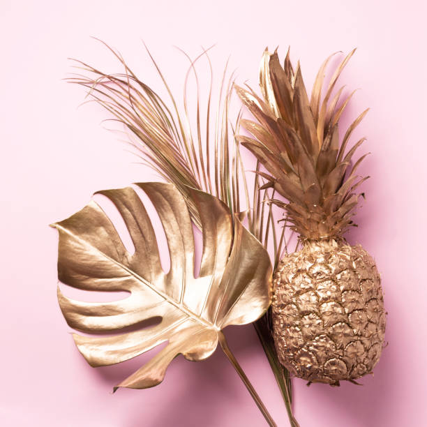 istock Creative layout. Gold pineapple and golden palm, monstera on pink background with copy space. Top view. Tropical flat lay. Exotic food concept, crazy trend. Banner 1155442262