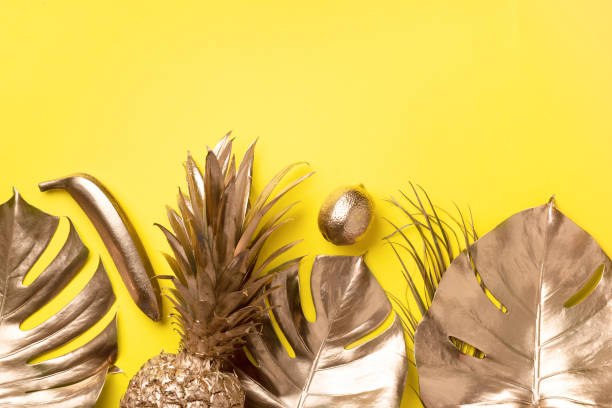 istock Creative layout. Gold pineapple and golden palm, monstera on yellow background with copy space. Top view. Tropical flat lay. Exotic food concept, crazy trend. Banner 1155443944