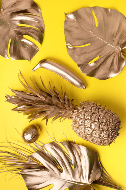 istock Creative layout. Gold pineapple and golden palm, monstera on yellow background with copy space. Top view. Tropical flat lay. Exotic food concept, crazy trend. Banner 1155444001