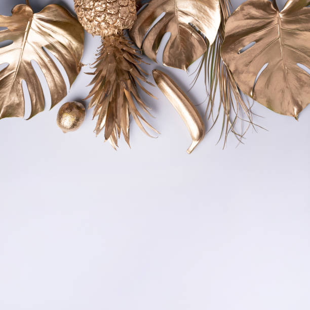 istock Creative layout. Gold pineapple and golden palm, monstera on grey background with copy space. Top view. Tropical flat lay. Exotic food concept, crazy trend. Banner 1155444057