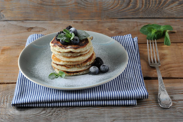 istock Appetizing pancakes are decorated with blueberries, blackberries, mint and sprinkled with powdered sugar. 1155444477